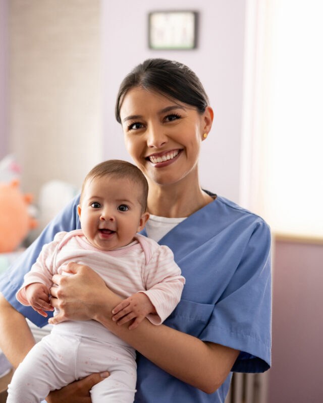 NYC Nanny Care - nanny holding a smiling baby